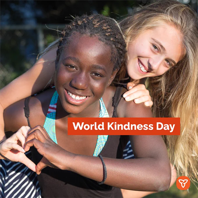 Two friends sitting together outside.
Text reads: World Kindness Day