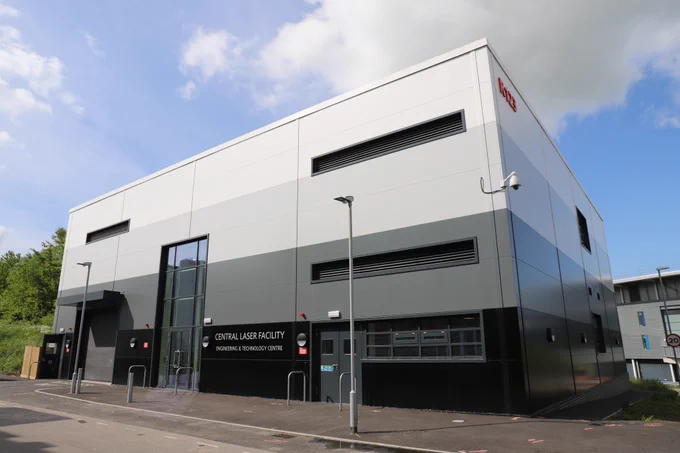 ETC building - a gradient dark to light grey square building with an entrance with a large glass window.