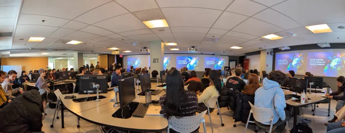 A room full of people watching a presentation 