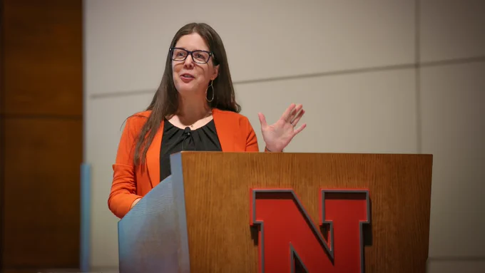Jessica A. Shoemaker, Steinhart Distinguished Professor of Law, speaks behind a wooden lectern with a red Nebraska "N" on the front. (Nick Kumpula/Research and Innovation)