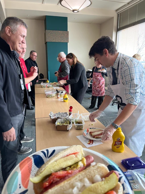 DOA staff line up for hot dogs during the Chicago Hot Dog Day fundraiser for Partners in Giving.