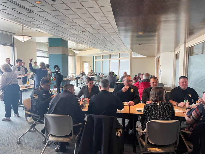 DOA colleagues gather around tables in the Wisconsin Room of the Administration Building for the Chicago Hot Dog Day fundraiser.