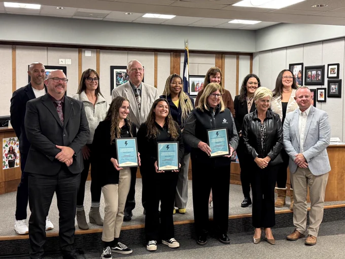 Several individuals at the Board of Education meeting holding Superintendent Excellence in Education Awards.