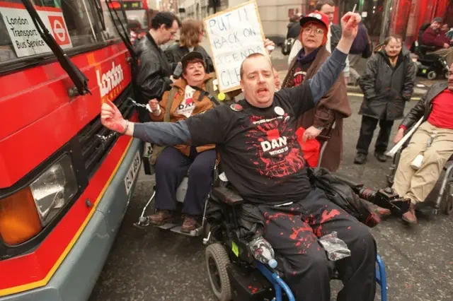 Image of DAN protestors blocking a bus in the road