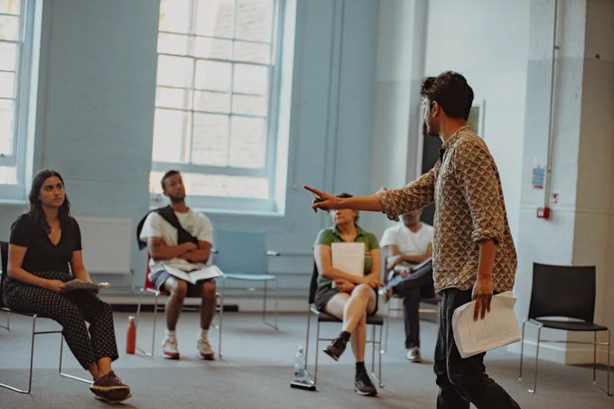 Atri Banerjee directs a group of actors in a rehearsal room
