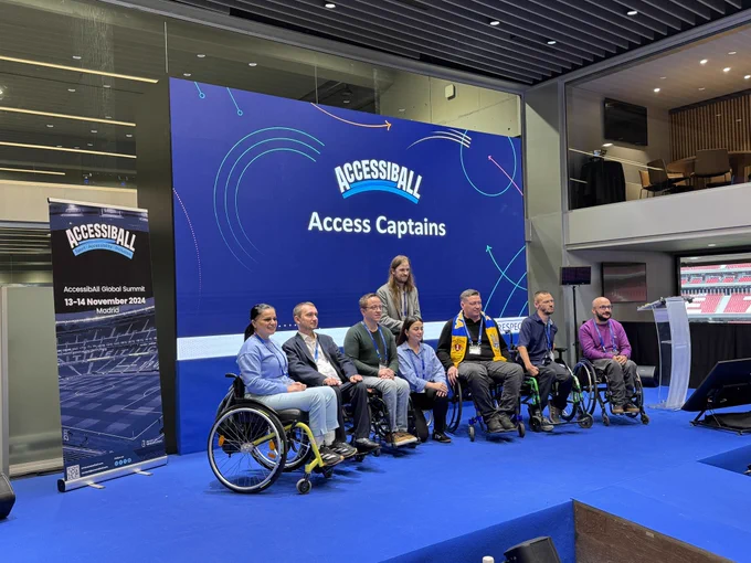 A selection of the first cohort of Access Captains on stage at the AccessibAll Global Summit. 8 people are on stage, 6 are wheelchair users