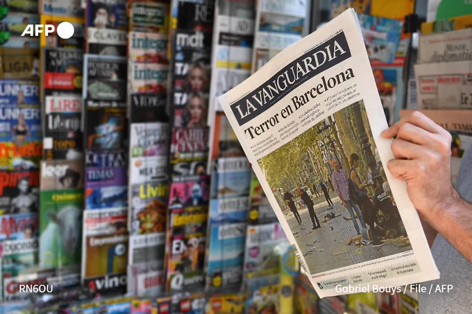 File photo shows a man reading a copy of newspaper La Vanguardia in Barcelona on August 18, 2017, a day after a van ploughed into the crowd, killing 13 people