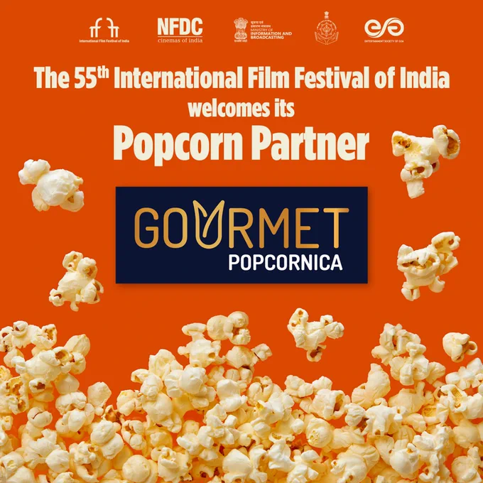 A vibrant poster for the 55th International Film Festival of India (IFFI) 2024. The background is a bright orange, and the center features a large image of popcorn. The text “Popcorn Partner” is displayed in bold white font. The logo of Gourmet Popcorn is prominently placed. At the top of the poster, various logos are visible, including those of NFDC, the Ministry of Information and Broadcasting, the Government of India, and myGov.