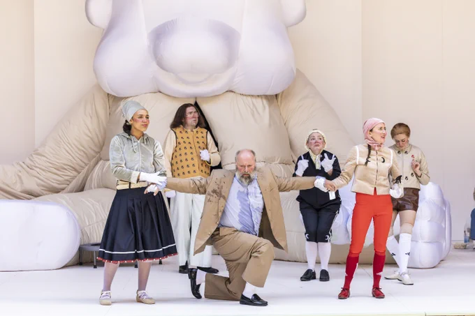The Company of The Taming of the Shrew (2024). 

A group of actors wearing whimsical costumes perform on stage in the Globe Theatre. 