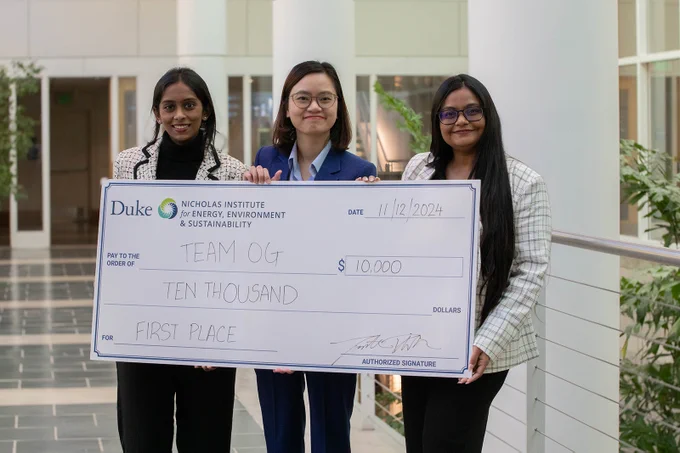 A team of graduate students from Syracuse University holds an oversized check for $10,000 for winning first place in the 2024 Energy in Emerging Markets Case Competition.