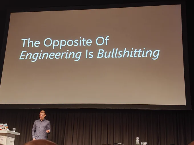 Projected slide, white on black: "The Opposite of Engineering is Bullshitting"