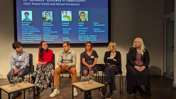 Six people on a panel discussion with presentation behind 