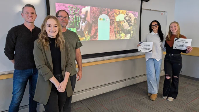 Bailey Lauerman Design Diversity Challenge judges and winners in front of a screen with the winning design.