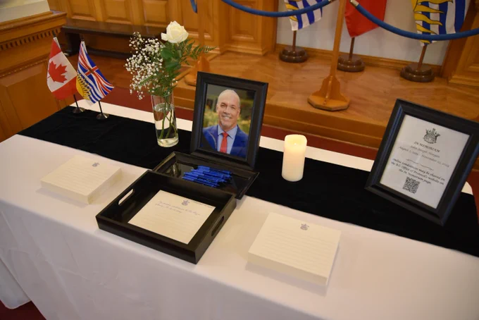 A table with a book of condolences for the late John Horgan
