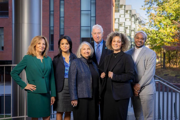 George Mason CHSS alumni pose in front of Fenwick Library on the George Mason University Fairfax campus.