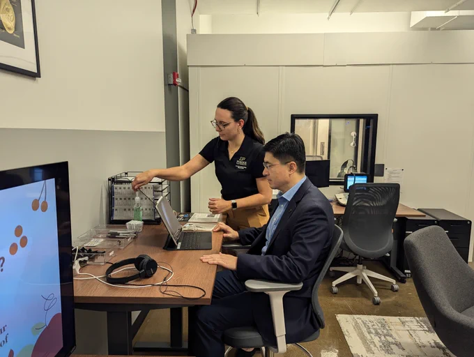 Alex Husted-Mai administers an exam to Purdue President Mung Chiang.