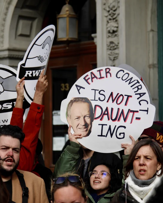 union supporters hold signs that say A FAIR CONTRACT IS NOT DAUNTING with a pic of B&N CEO James Daunt's face