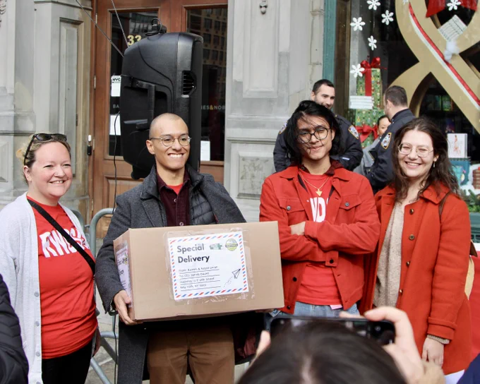 four Barnes & Noble workers outside the Union Square flagship with a box of letters they're about to deliver to management