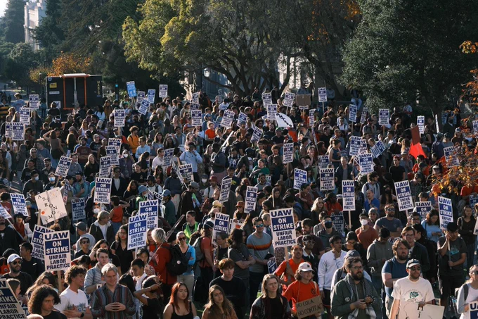 Big crowd of people holding picket signs