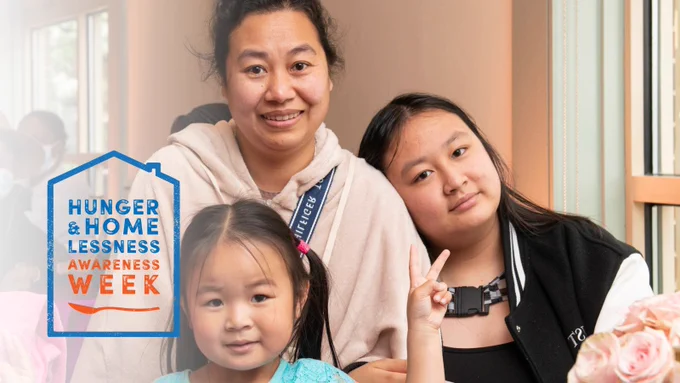 A guest and her daughters smile together in the Rosie’s Place Dining Room. The Hunger and Homelessness Awareness Week logo. 