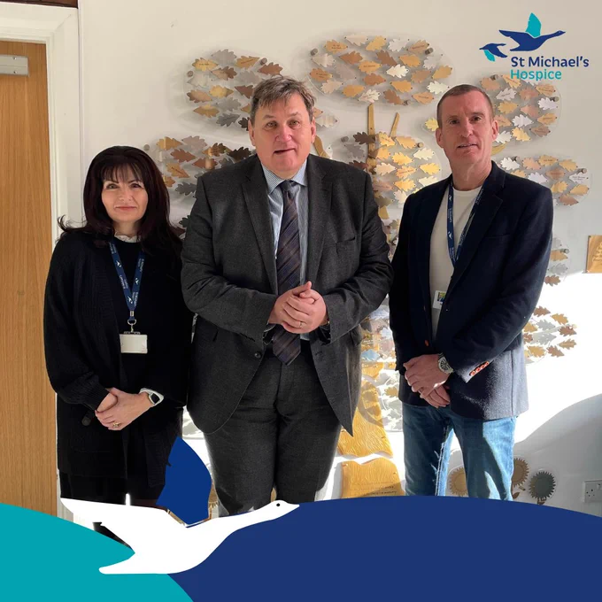 Image of Lorraine Pink, Kit Malthouse and Iain Cameron standing in front of our gold Hospice memory tree