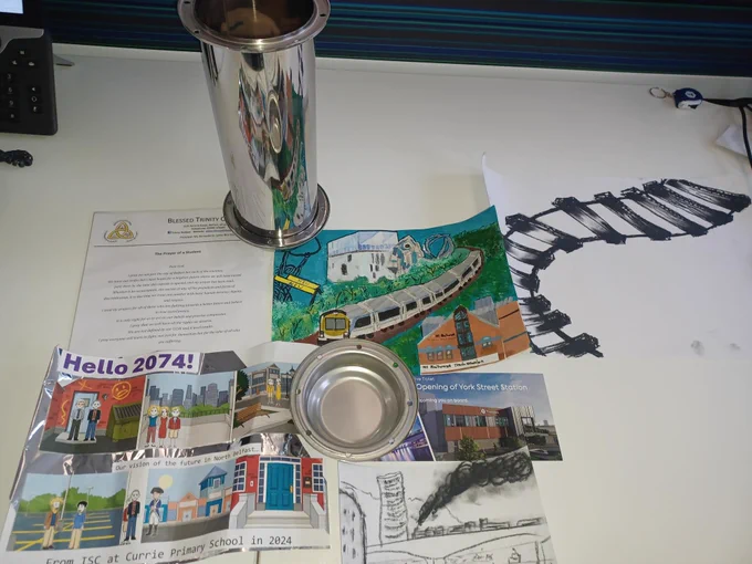 Image of items to be placed in time capsule including drawings, a prayer and York St opening day commemorative ticket