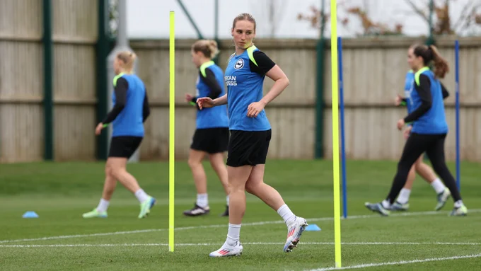 Bex Rayner running in training wearing the blue and black training kit.