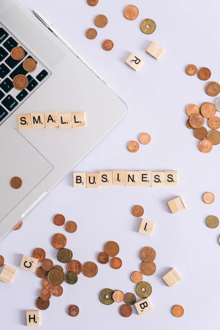 coins on a table with the words 'SMALL BUSINESS' on scrabble letters.