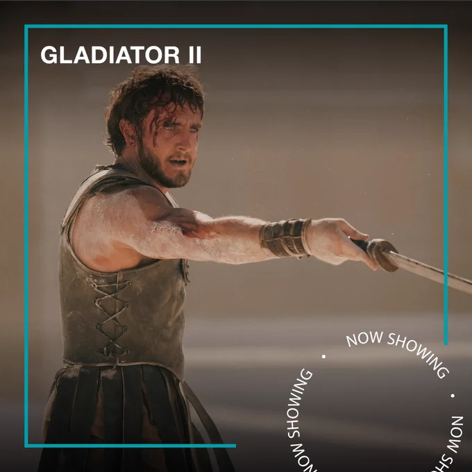 Paul Mescal as a gladiator, covered in sand and blood. Text - Gladiator II, Now Showing
