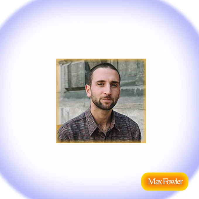 Max, a white skinned non-binary person, wears a reddish over-sized button down as they sit in front of a stone wall smiling slightly. 