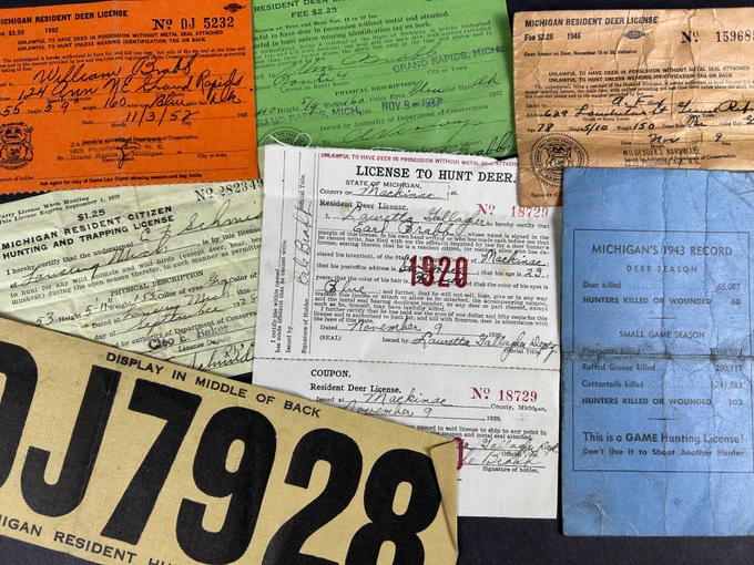 A close up of a variety of paper hunting licenses.
