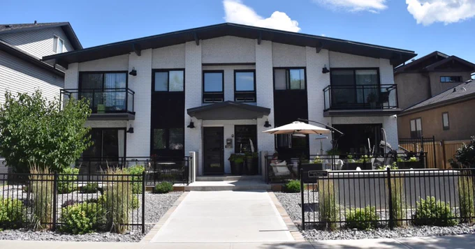 A two story, multi-unit residential building in Edmonton that has been retrofitted with solar panels and green upgrades