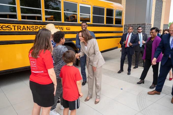 Vice President Harris greets children during a tour of electric school buses in Falls Church, Virginia.