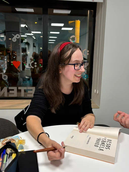 Imagen de mí el día de la presentación sonriendo muy contenta e incrédula a una lectora.