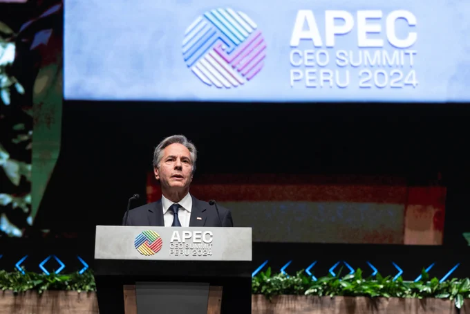 Standing behind a podium, Secretary Blinken delivers remarks at a CEO Summit on the margins of the APEC Summit in Lima, Peru, November 15, 2024. Signage overhead reads: APEC CEO Summit Peru 2024 (Official State Department photo by Chuck Kennedy)