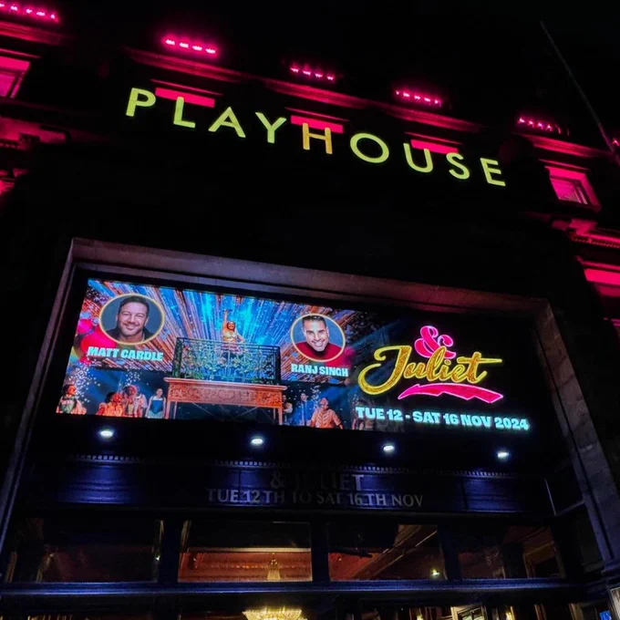 The front of house in Edinburgh with signs for & Juliet on, lit up at night time.