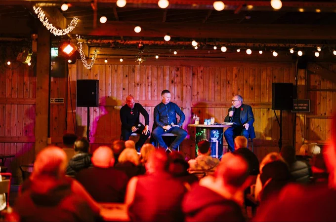 Tom Ross on stage presenting with Martin O'Connor & Paul Tait in front of a large audience