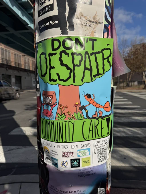 A poster on a pole on a city street that says “don’t despair! Community care!” With a shrimp watering some plants and a crab holding up a box of food. Underneath there’s a list of community groups and a QR to learn more about all the groups