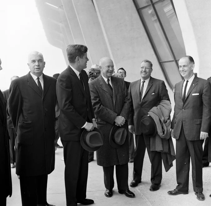 JFK stands with a group of men, including administrator of the FAA Najeeb Hallaby and President Eisenhower.