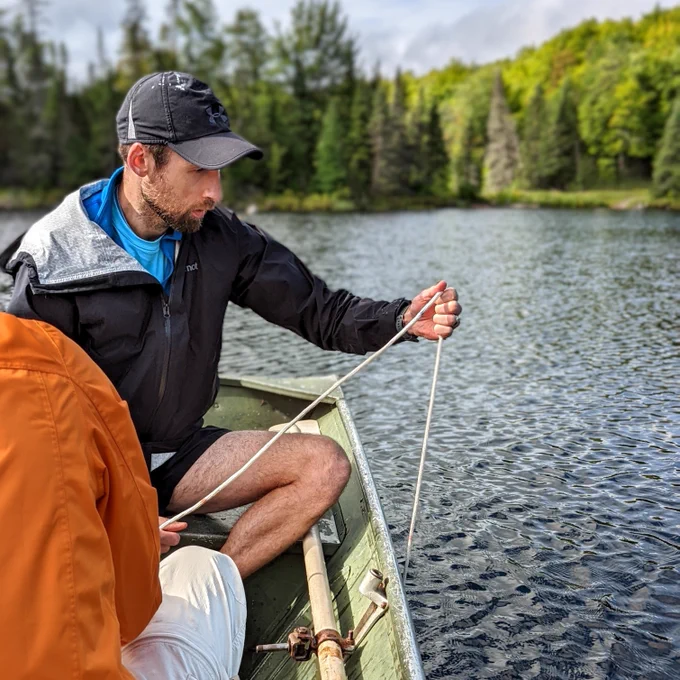 Jonathan Walter sampling on a boat for limnological field research