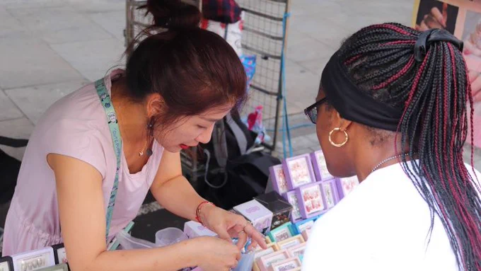 Market trader Yu Fang Chen and a customer on her market stall