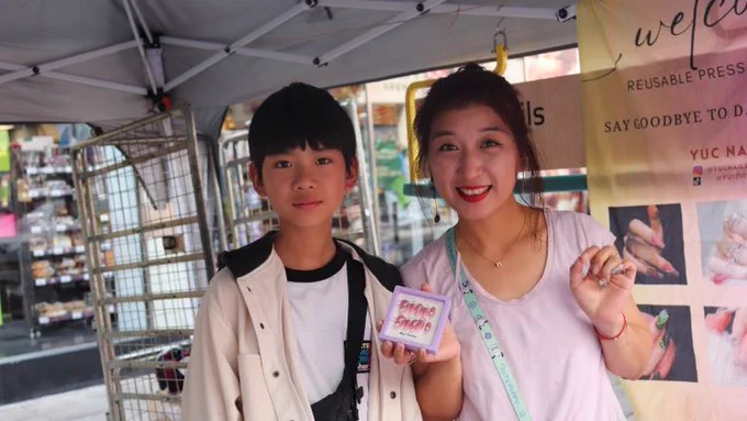 Market trader Yu Fang Chen and her son on her stall