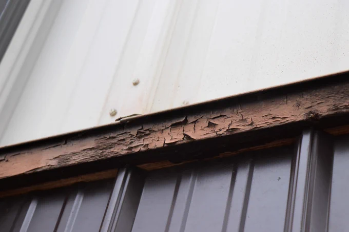Close-up of a dark brown wooden beam on a Chief Dull Knife building, which is rotting.