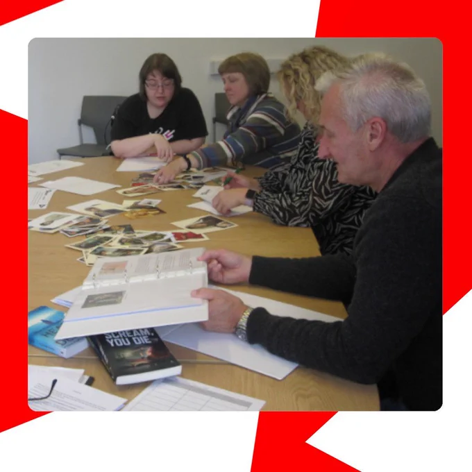 Four adults sit around a laminate-topped- table in a library enjoying a crime writing activity at Swinton Library Fun Palace in October 2024.
