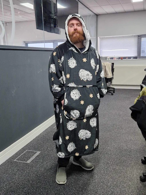 Man stood in a long grey oodie in Vizion Network's office space in The Deep Business Centre. 