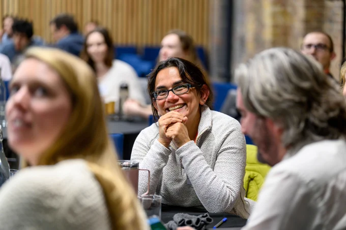 A female researcher smiling in the audience of the 2024 ECR conference.