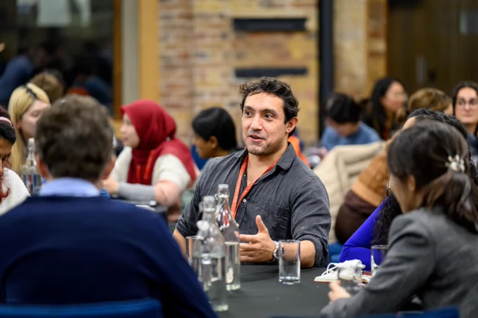 A male researchers talking to colleagues in the audience of the 2024 ECR conference.