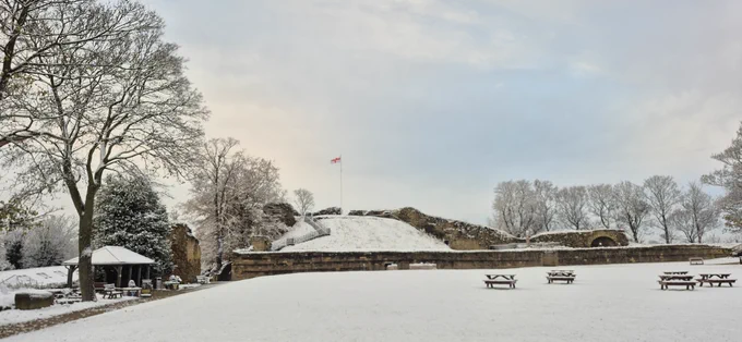 The top of the keep and castle bailey with a dusting of snow, and the St George's flag flying proudly in the crisp wintry breeze