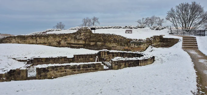 Part of the remains of a chapel at Pontefract Castle and surrounding walls covered in a dusting of snow