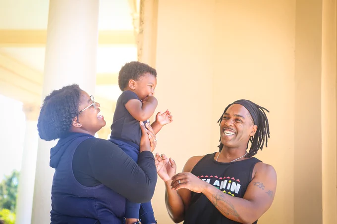 Image of parents and young child playing and laughing together